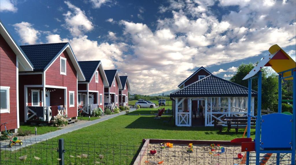 a row of houses with a playground in the yard at Pirat domki letniskowe Bobolin in Bobolin