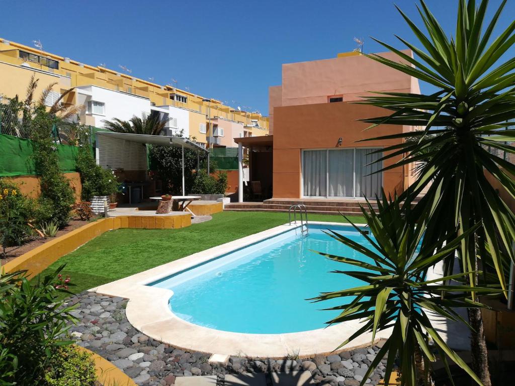 a swimming pool in a yard next to a building at Vivienda Unifamiliar Sela in Santa Cruz de Tenerife