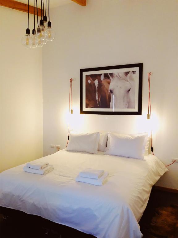 a bedroom with a white bed with two towels on it at El Establo in Puerto Natales