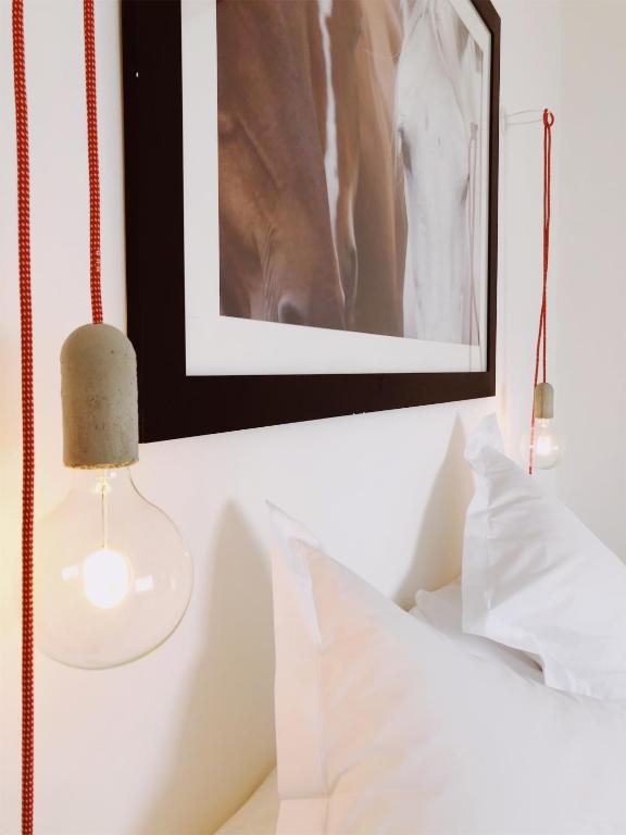 a bedroom with a picture and a lamp on a bed at El Establo in Puerto Natales