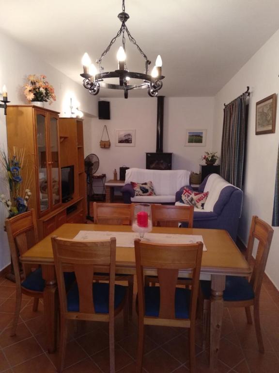 a dining room and living room with a table and chairs at Casa Rural Cerca Del Caminito Del Rey Ardales in Ardales