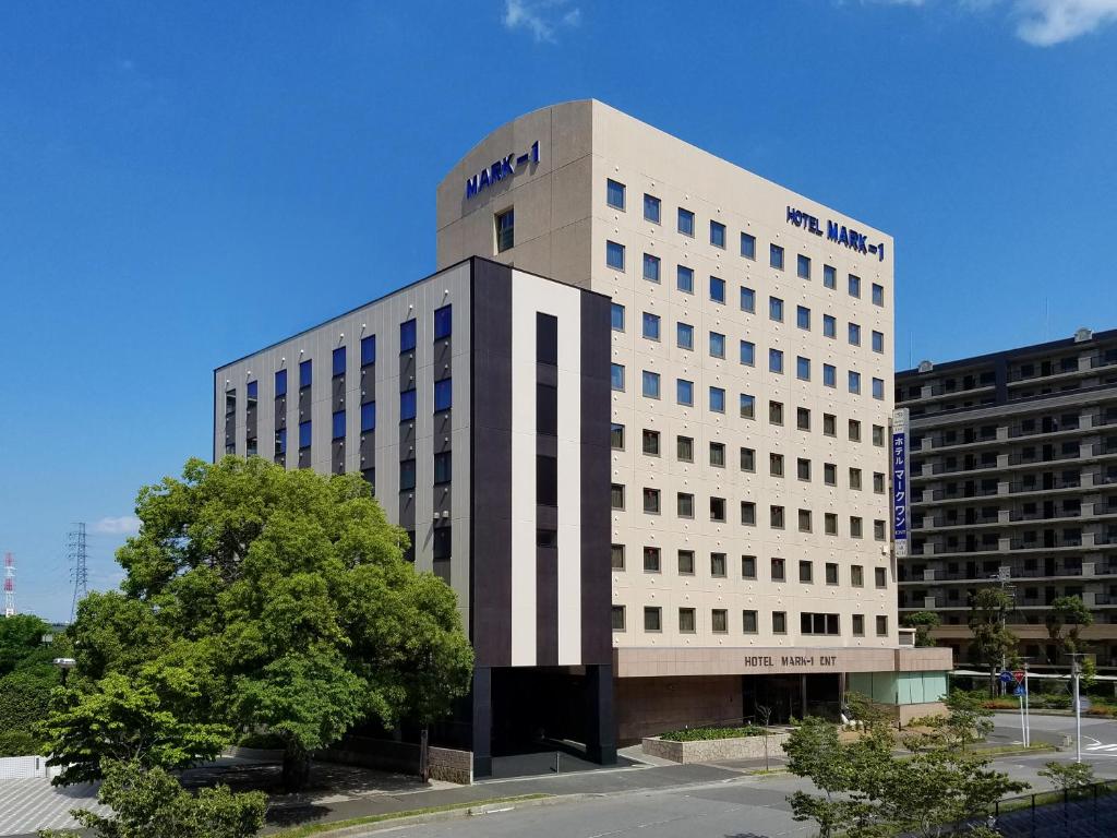 a tall white building with a sign on it at Hotel Mark-1 CNT in Inzai