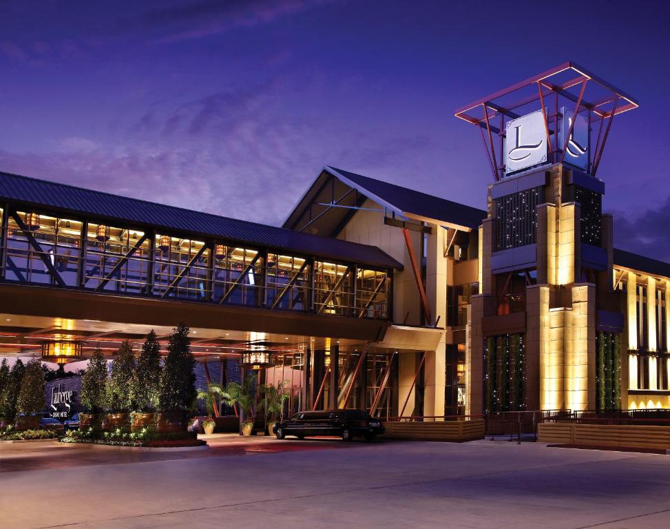 un grande edificio con torre dell'orologio di notte di L'Auberge Baton Rouge a Baton Rouge