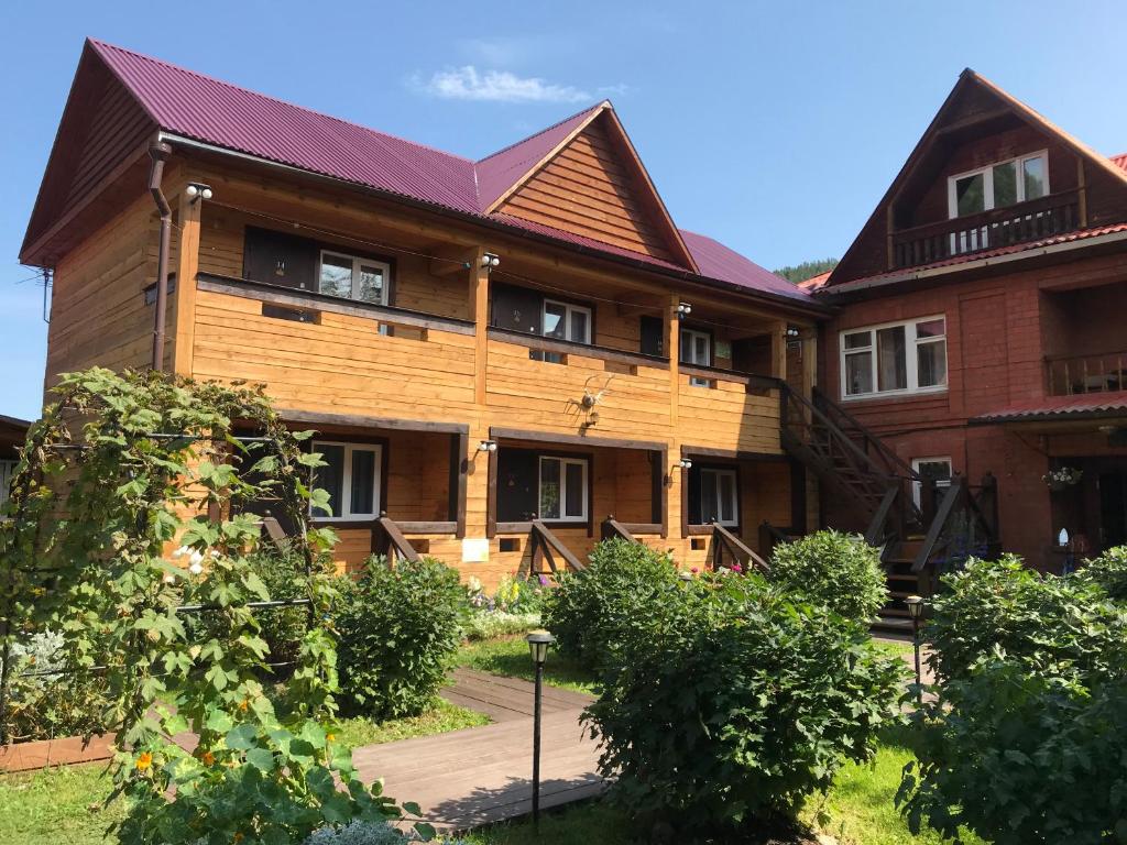 a large wooden house with a pathway in front of it at Hotel Dauria in Listvyanka