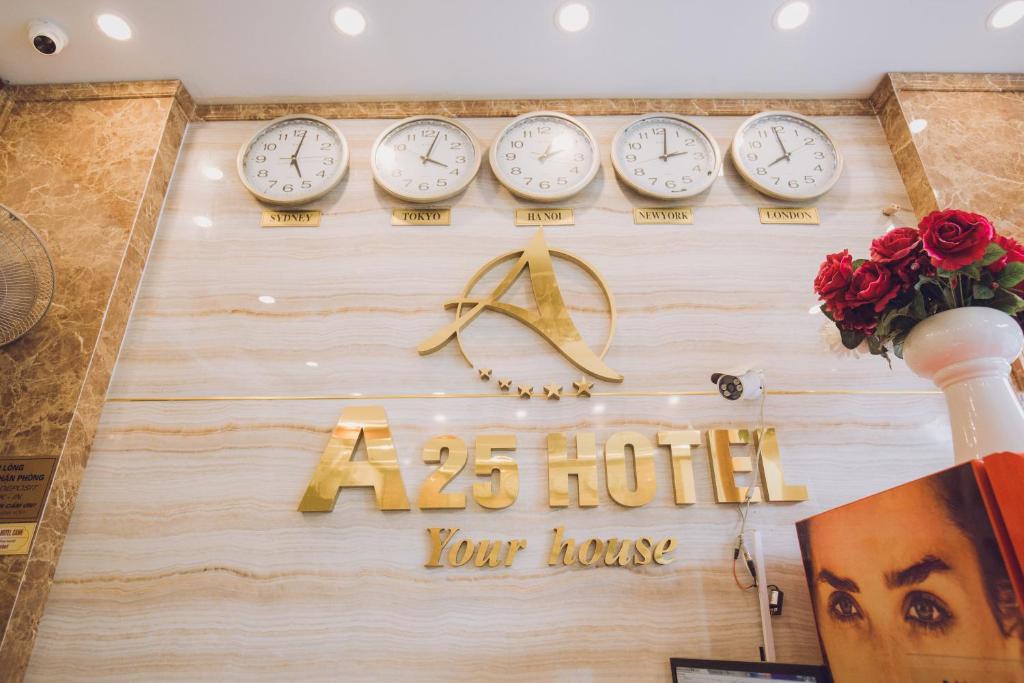 a hotel sign with clocks on a wall at A25 Hotel - 197 Thanh Nhàn in Hanoi