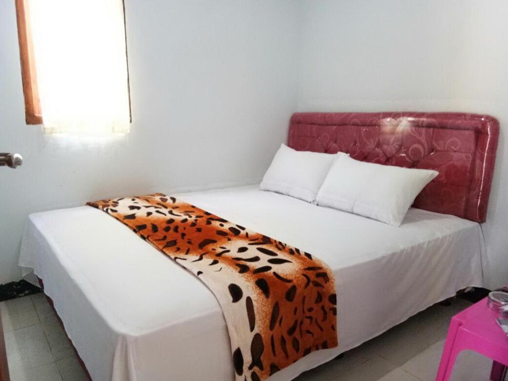 ein Schlafzimmer mit einem Bett mit einer Leoparden-Decke darauf in der Unterkunft Agung Safira Homestay in Bromo