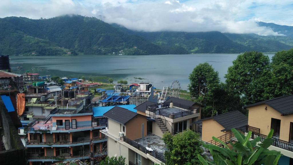 a city with houses and a lake in the background at peace guesthouse cottage in Pokhara