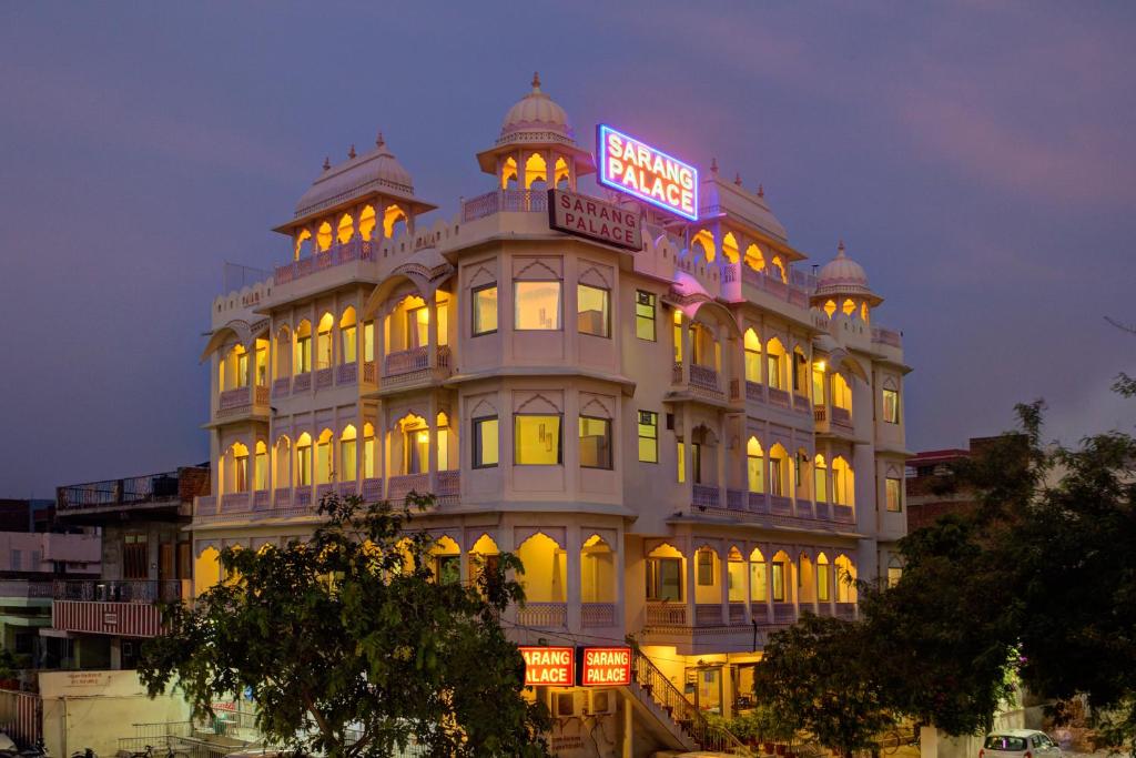 a building with a neon sign on top of it at Hotel Sarang Palace - Boutique Stays in Jaipur