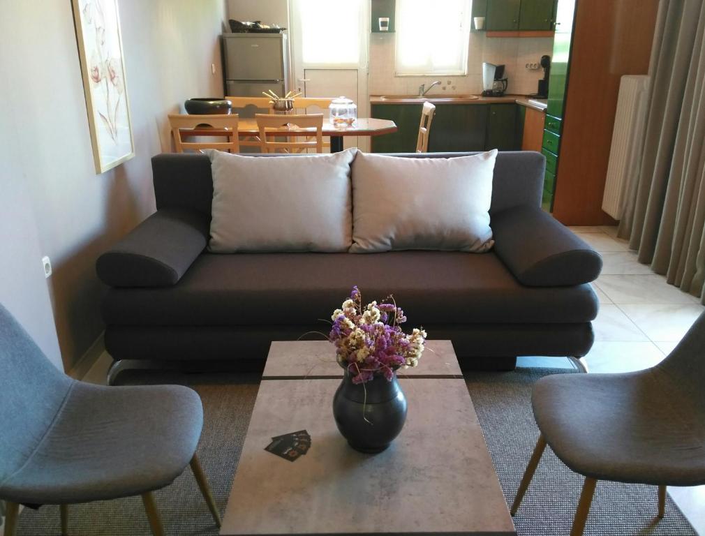 a living room with a couch and a vase of flowers on a table at Theanthi in Nafplio