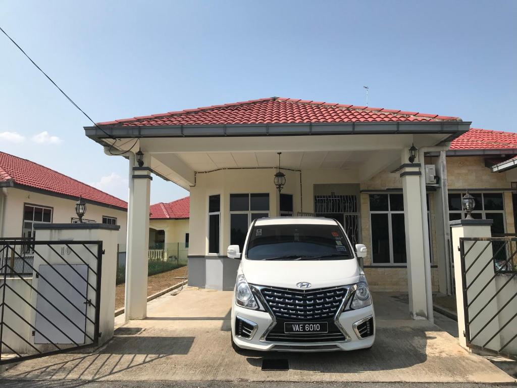 a white car parked in front of a house at PATIN GUEST HOUSE @DESA TELOK IRA, TEMERLOH PAHANG in Kampong Paya Kerinau