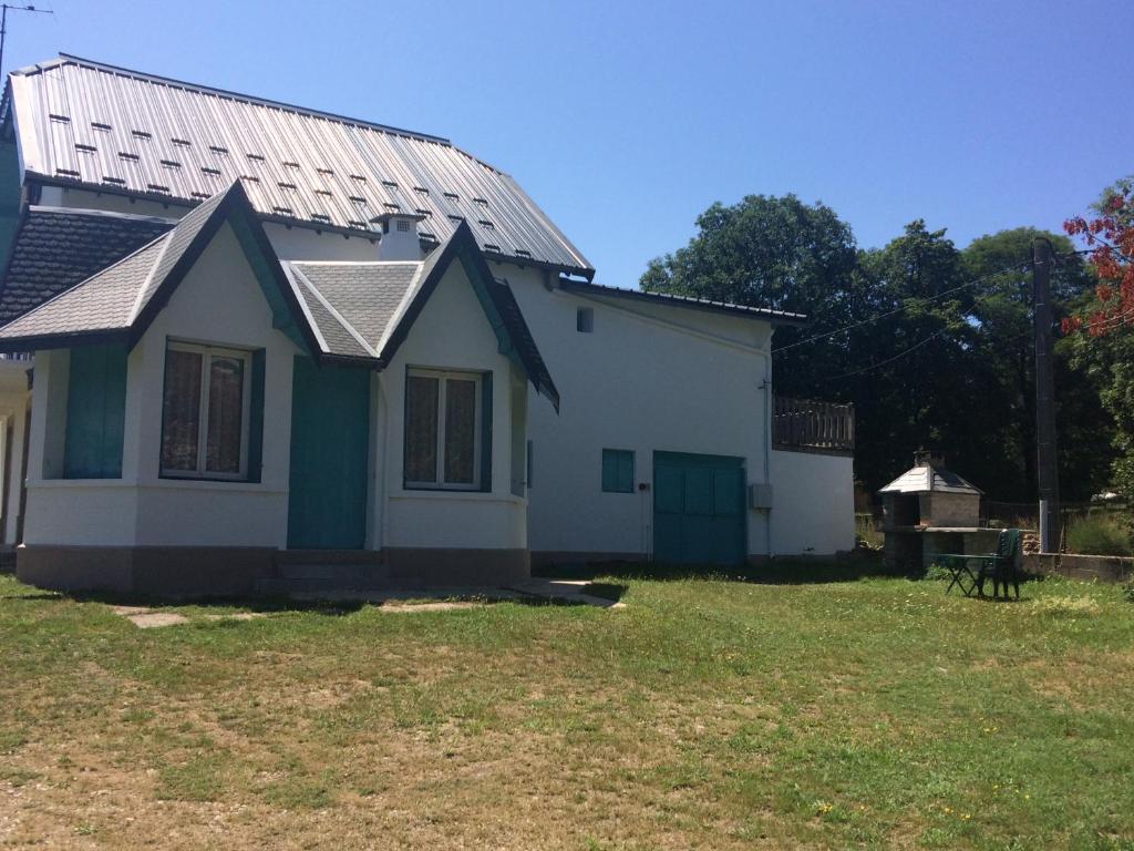 une petite maison blanche avec un toit en métal dans l'établissement Appartement au cœur du parc national des Cévennes, à L'Espérou