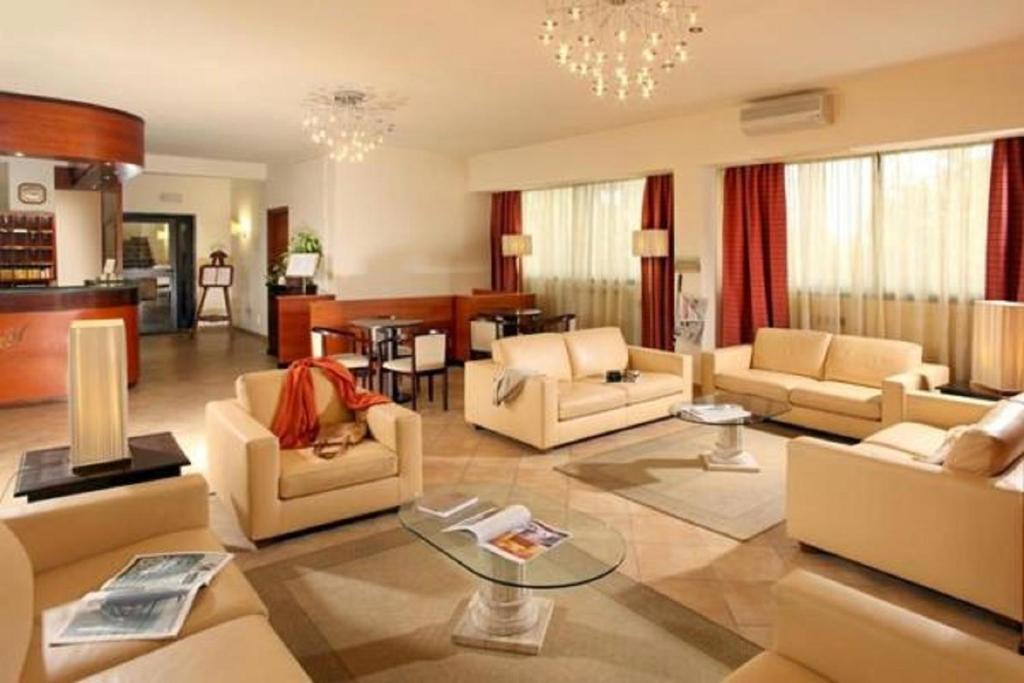 un ampio soggiorno con divani e tavolo di Hotel Cassia a Roma