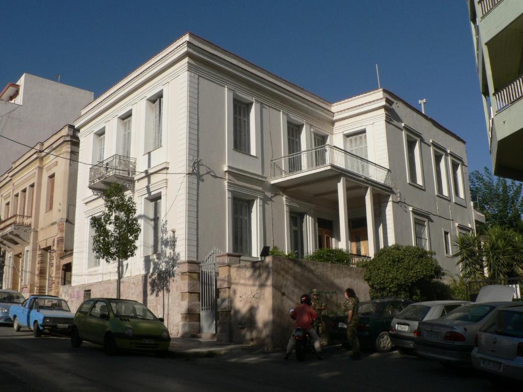 a white house with people standing in front of it at 1906 Citygarden in Chios