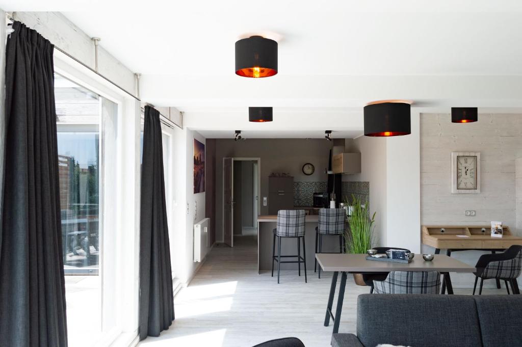 a living room with a table and a dining room at StrandBerg's Auberge Chalet Residences in Braunlage