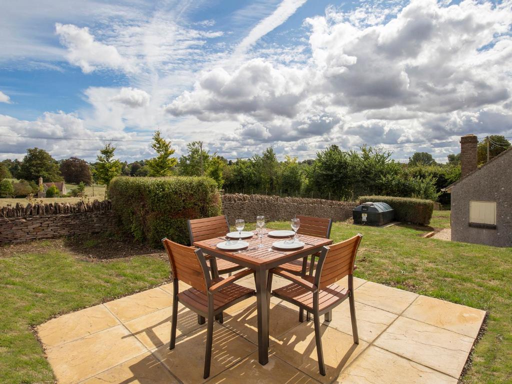 un tavolo e sedie seduti su un patio di Meadow View a Cirencester