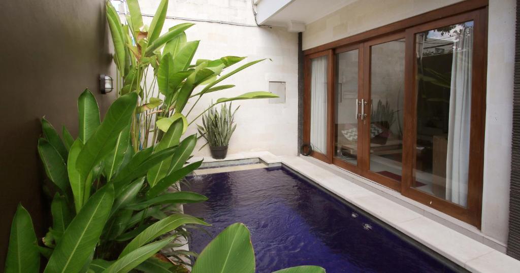 un estanque koi cubierto en una casa con plantas en Villa Anyelir en Seminyak