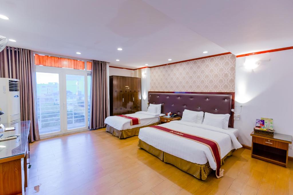 a hotel room with two beds and a balcony at A25 Hotel - 46 Châu Long in Hanoi