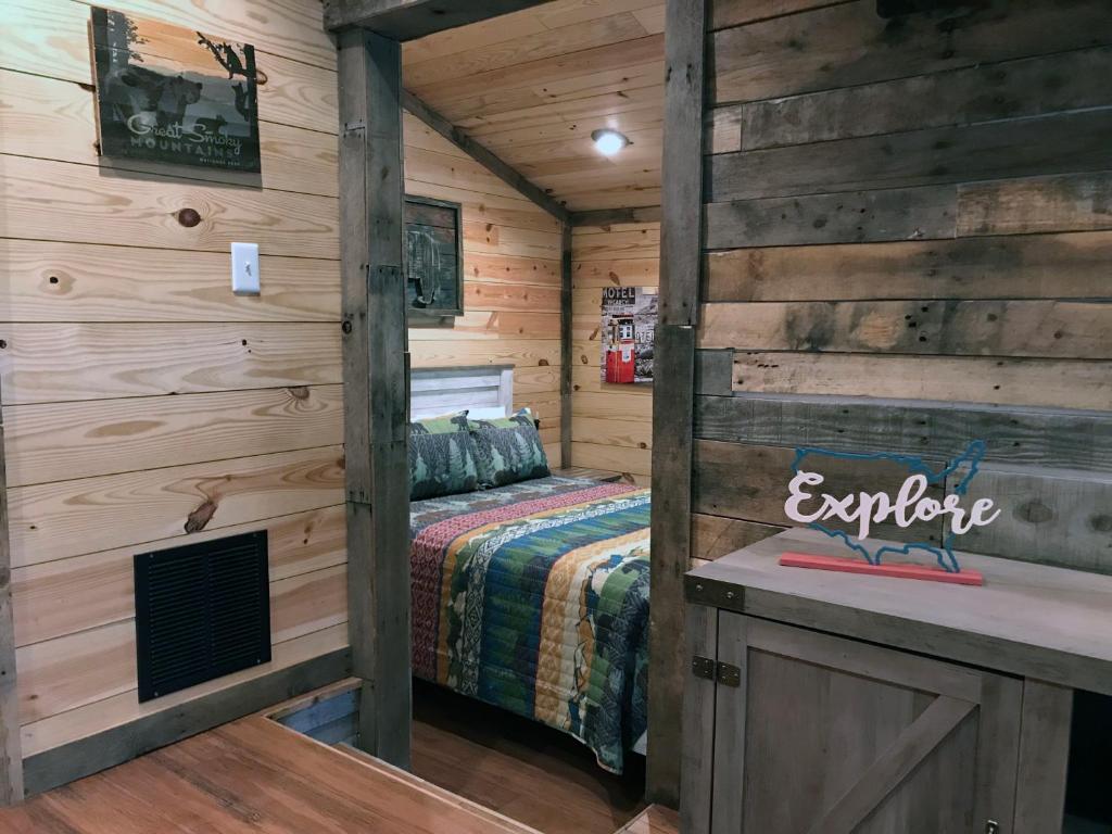 ein Schlafzimmer mit einem Bett in einer Holzhütte in der Unterkunft Art Loft in Sevierville