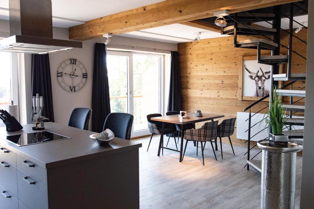 eine Küche und ein Esszimmer mit einem Tisch und Stühlen in der Unterkunft StrandBerg's Auberge Chalet Residences in Braunlage