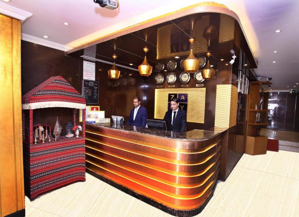 two men standing at a bar in a restaurant at Zagy Hotel in Dubai
