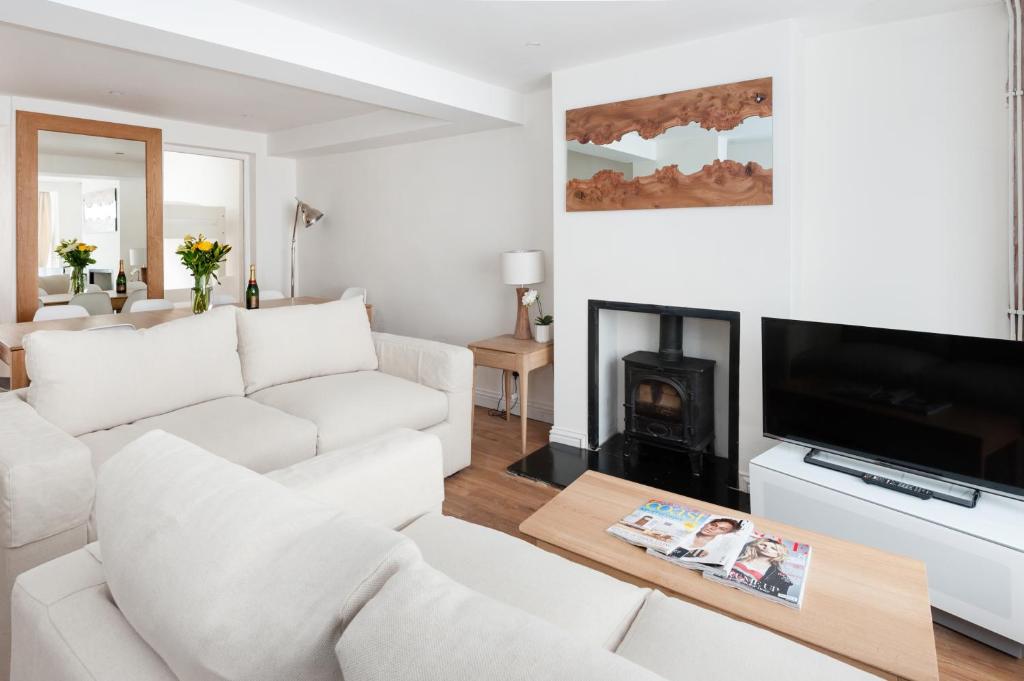 a white living room with a white couch and a fireplace at Sea Breeze Cottage with Parking in Brighton & Hove