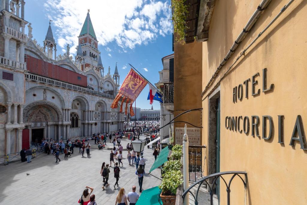 Eine Gruppe von Menschen, die in einem Gebäude eine Straße hinuntergehen in der Unterkunft Hotel Concordia in Venedig