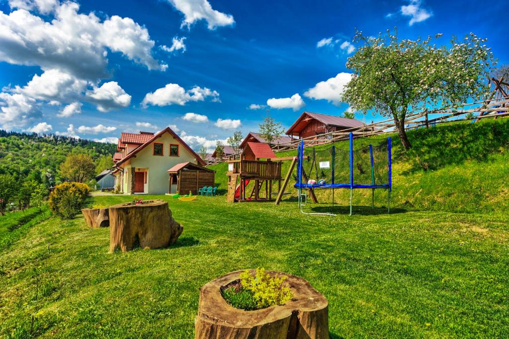 a yard with a playground and a swing at domki z kominkiem in Polańczyk