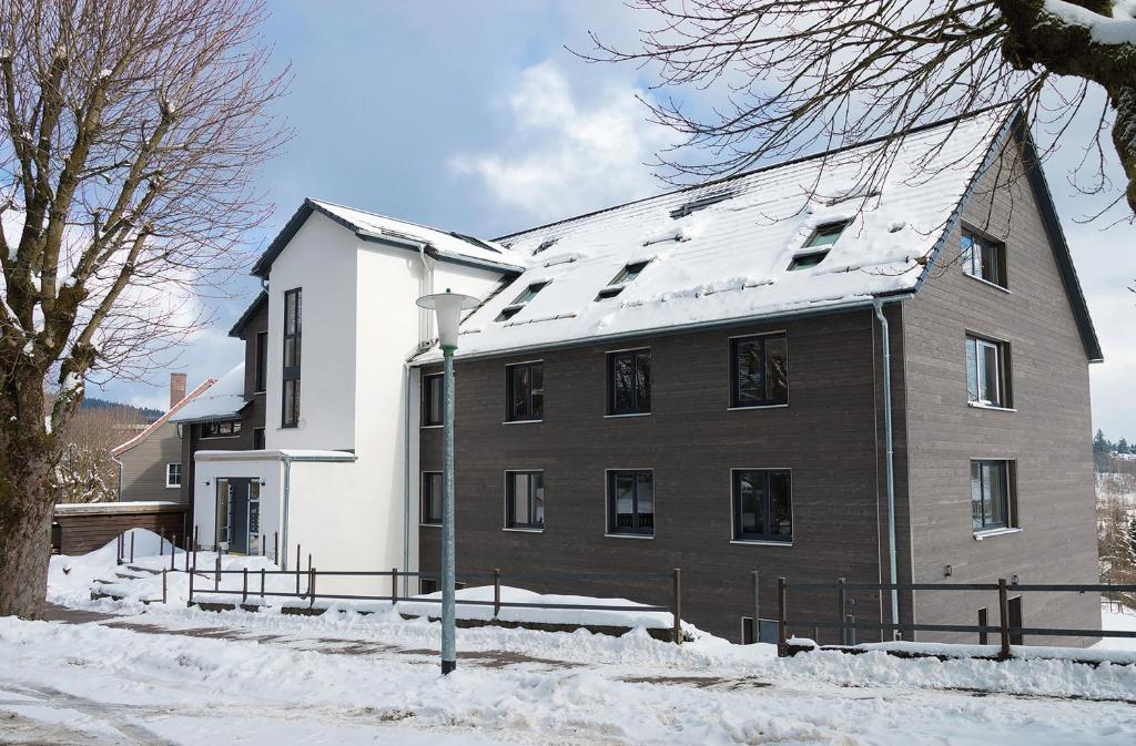 a large building with snow on the ground in front of it at StrandBerg's Auberge Chalet Residences in Braunlage