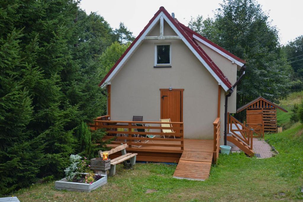 a small house with a porch and a deck at Domek Klimaty Kamieńczyk in Międzylesie