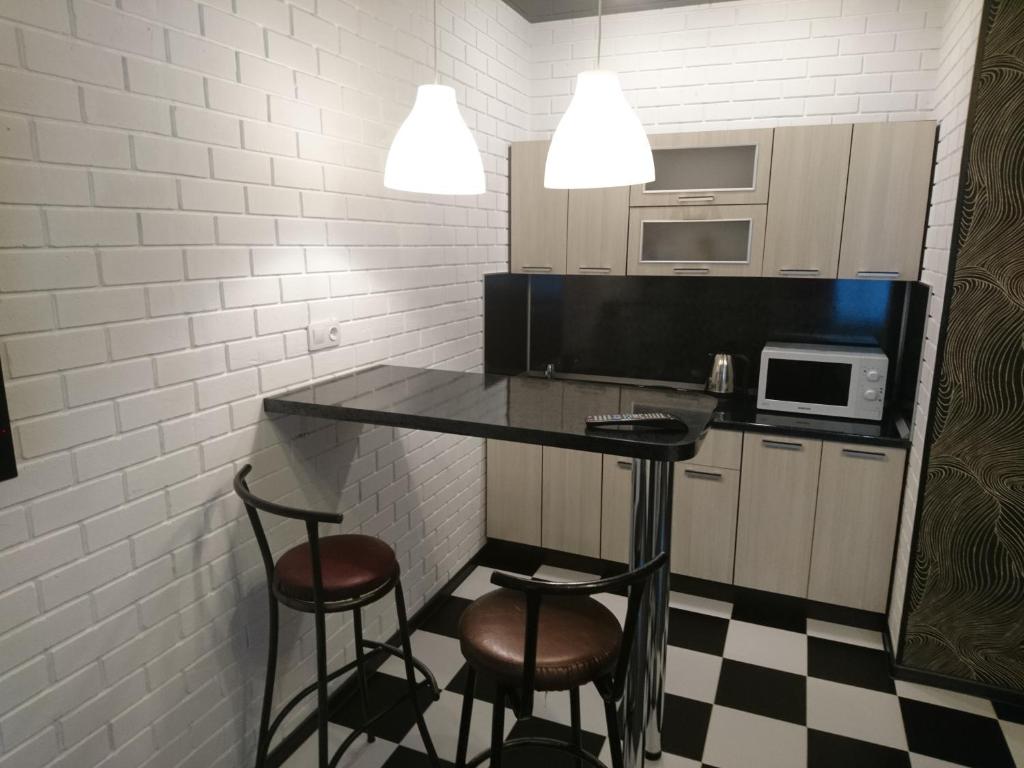 a kitchen with a table and two stools in a room at Studio Loft in Saransk