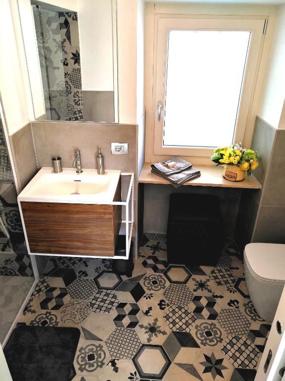łazienka z umywalką, lustrem i toaletą w obiekcie B&B "Madama Granèt" w mieście Borgo San Dalmazzo