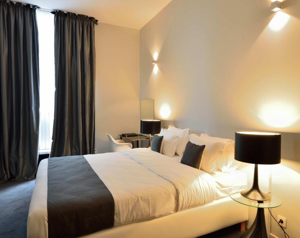 a hotel room with a large bed and a window at Hotel Retro in Brussels