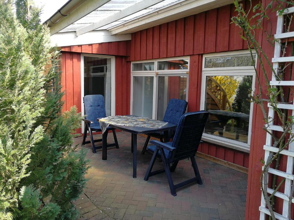 een patio met stoelen en een tafel op een huis bij Finnenhaus in Neumünster