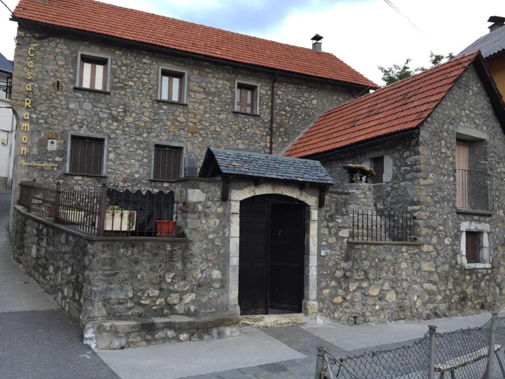 un antiguo edificio de piedra con una puerta negra en Casa Ramón La Caseta, en Sin