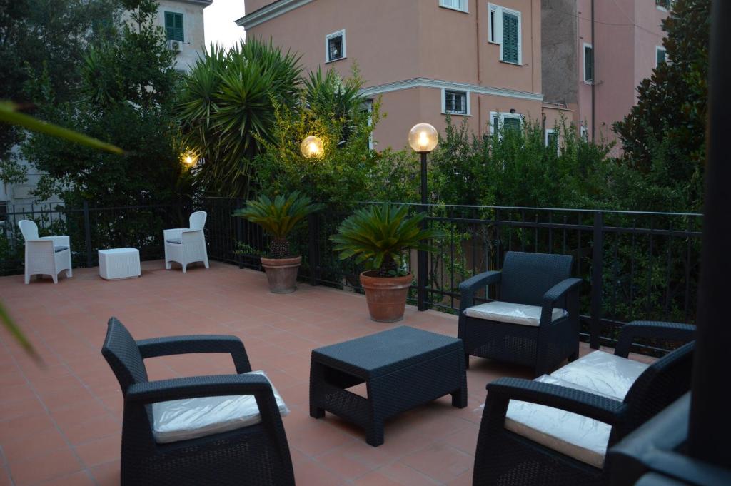 un patio con sillas, mesas y una valla en L'Oasi al Pigneto - Guest house en Roma