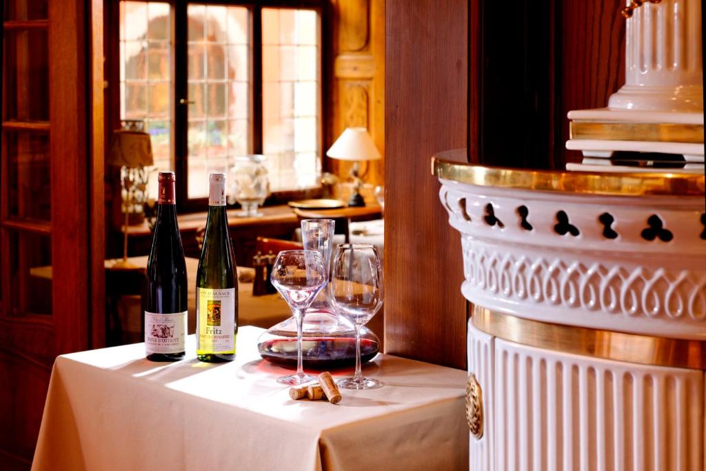 a table with wine bottles and glasses on it at Hotel Restaurant L&#39;Ami Fritz in Ottrott