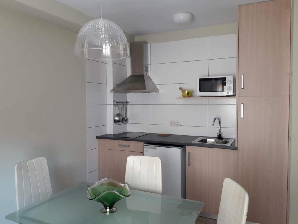 uma cozinha com uma mesa de vidro e electrodomésticos brancos em Ca la Pagesa em San Lorenzo de Morunys