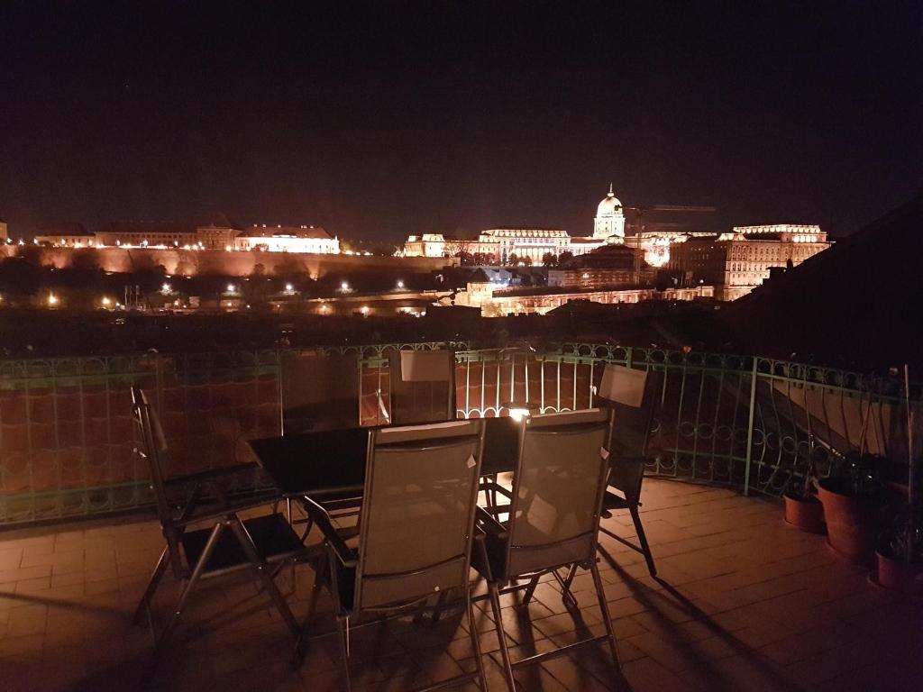 a table and chairs on a balcony at night at Penthouse with Free PARKING and Free BIKES, wellness 8 min walk in Budapest