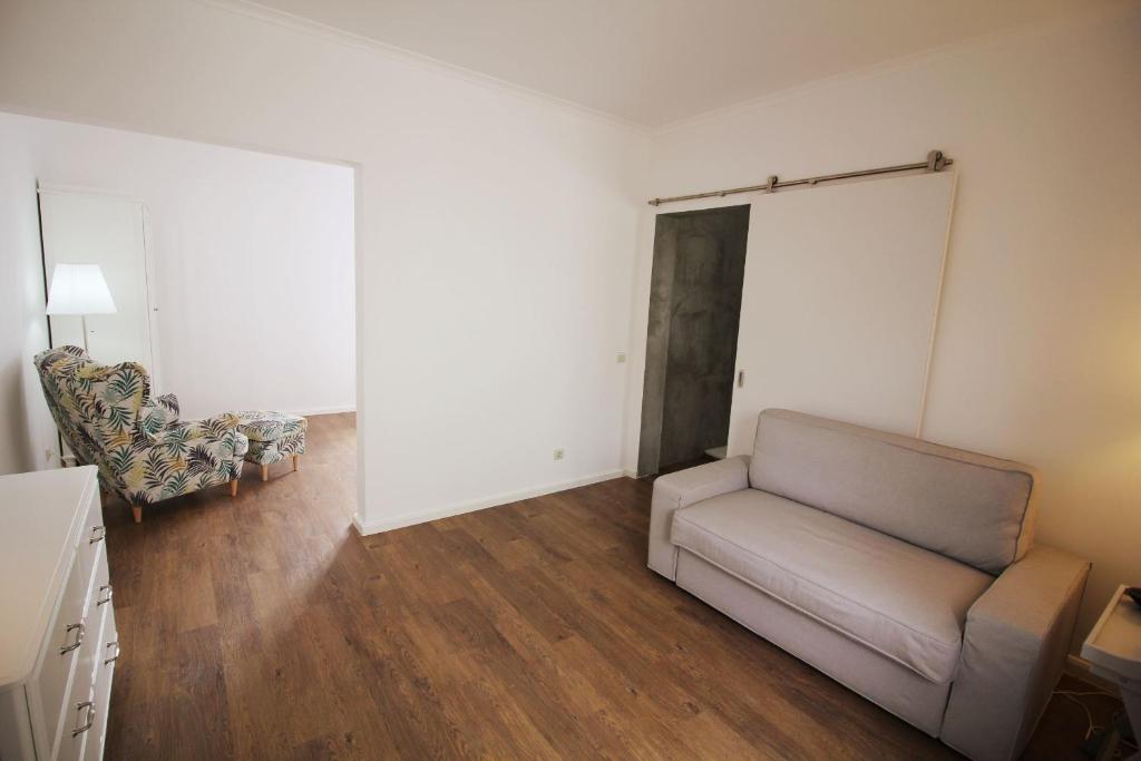 a living room with a couch and a chair at Vinha da Areia Beach Hotel in Vila Franca do Campo