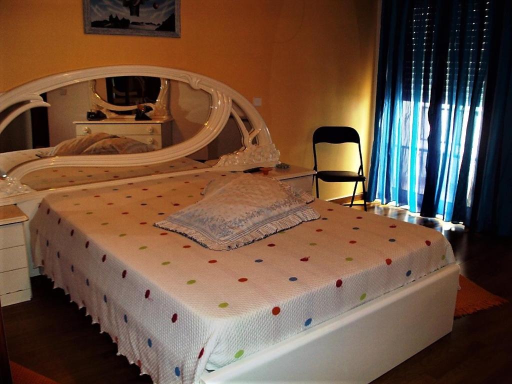 Un dormitorio con una cama blanca con lunares. en Edificio Saul Fanha, en Nazaré