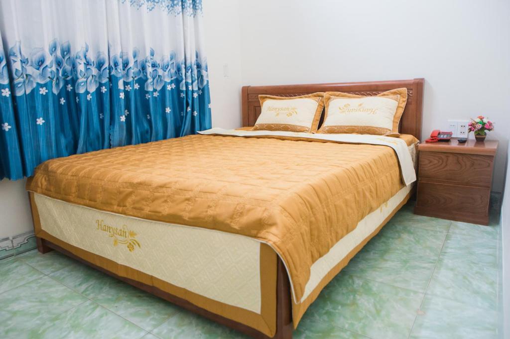 łóżko w sypialni z niebieską zasłoną w obiekcie Triệu Hoàng Hotel w mieście Quy Nhơn