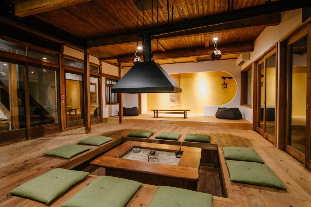 a living room with green cushioned chairs and a table at Irori Guest House Tenmaku in Hakone