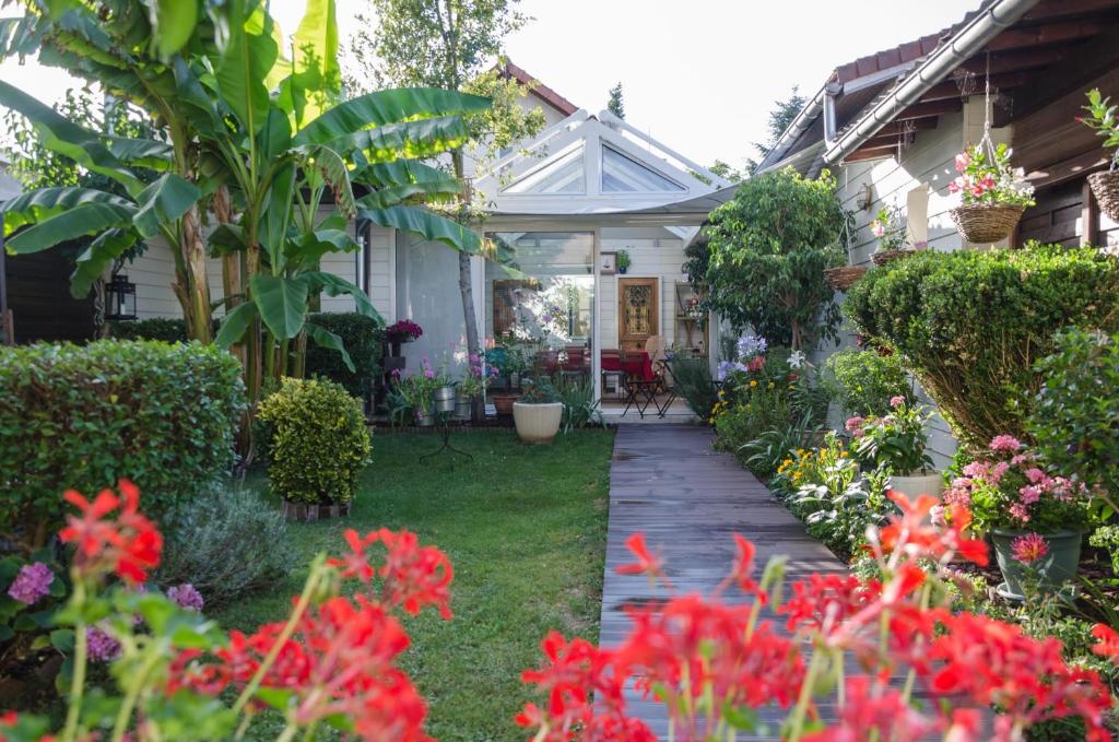 un jardín con flores rojas y una casa en L'ISLE DE FRANCE en Conflans-Sainte-Honorine