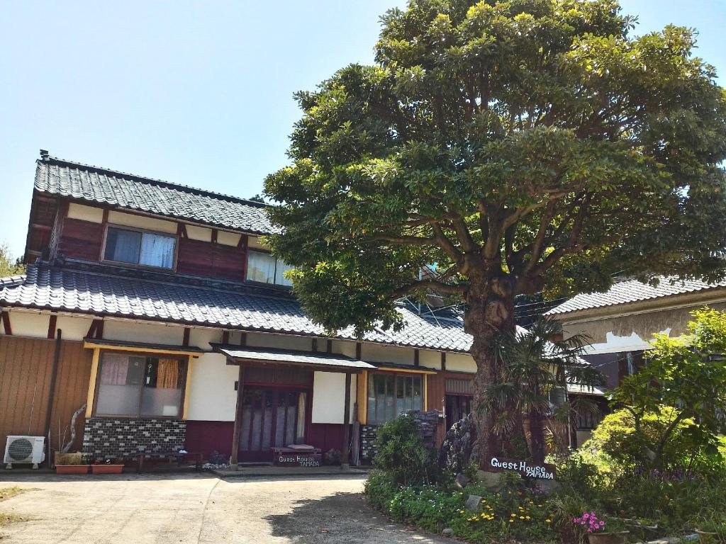 福井市にある越前ゲストハウスTAMADAの木の前の建物