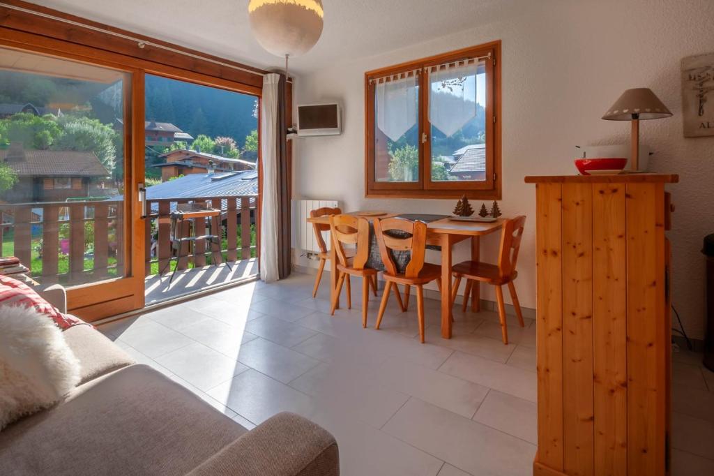un salon avec une table et des chaises et un balcon dans l'établissement Marquis 5, à Morzine