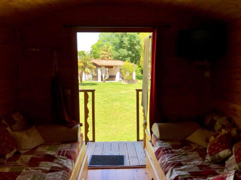 a view of a room with a door open to a yard at les roulottes de dilou Cerise in Matha