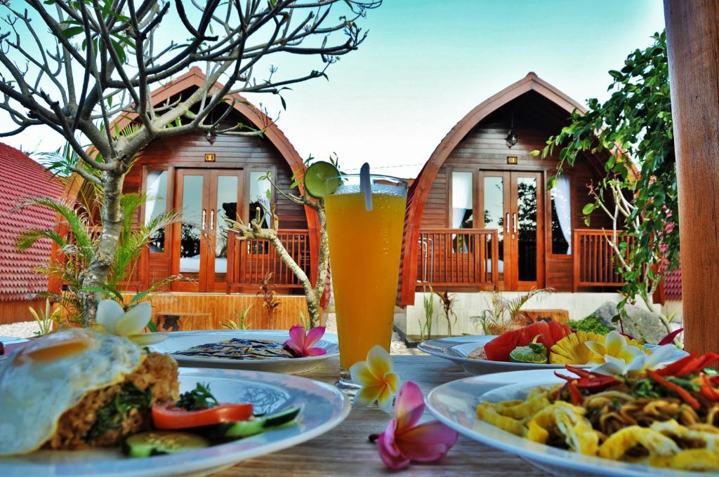 una mesa con platos de comida y bebida en Setilas Bungalows en Nusa Penida