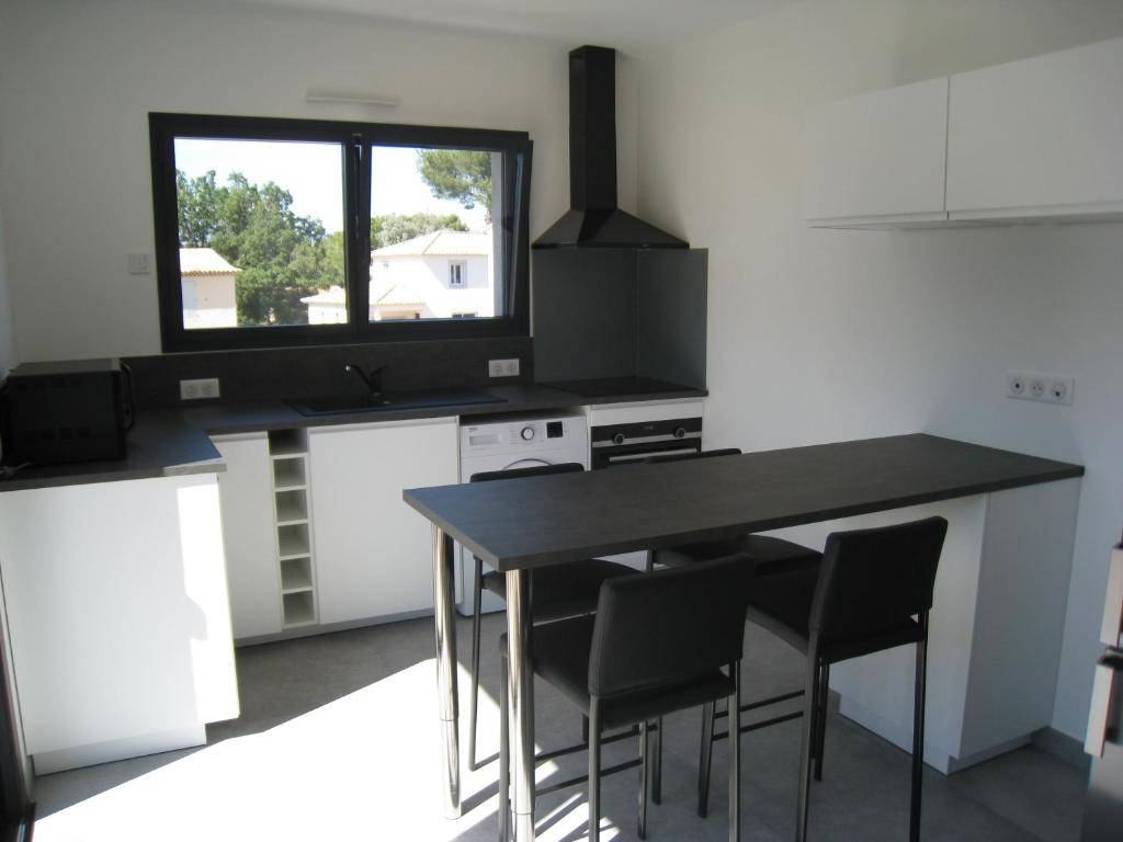 een keuken met een tafel en stoelen en een raam bij VILLA M&M in La Seyne-sur-Mer