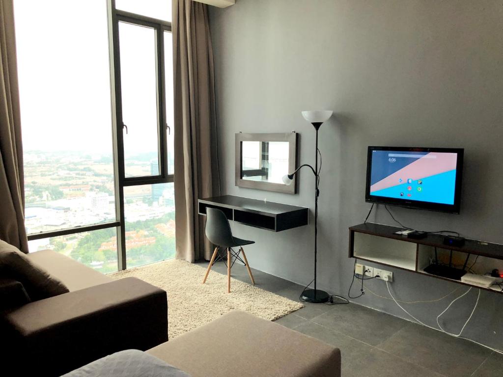 uma sala de estar com uma televisão e uma secretária com um espelho em Empire Damansara Residence Suites em Petaling Jaya