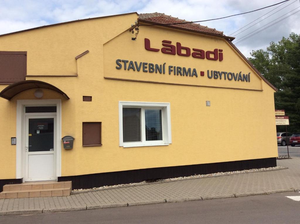a yellow building with a sign on the side of it at Ubytování Lábadi in Rohatec